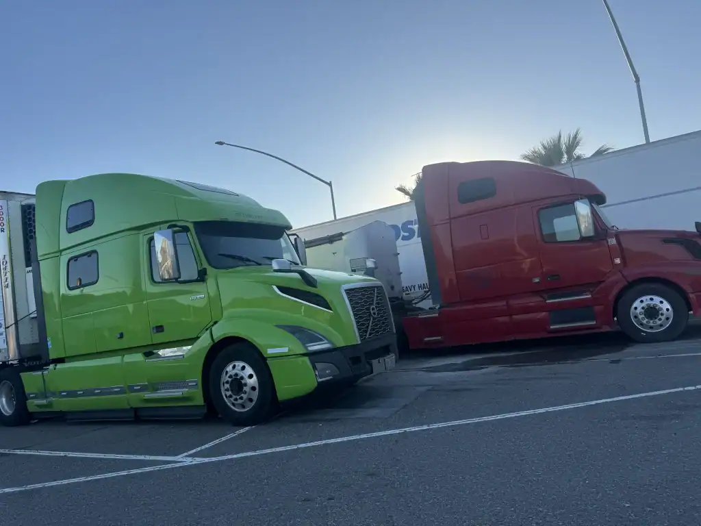 Green and red semi-trucks parked curbside after Clean Truck Check testing