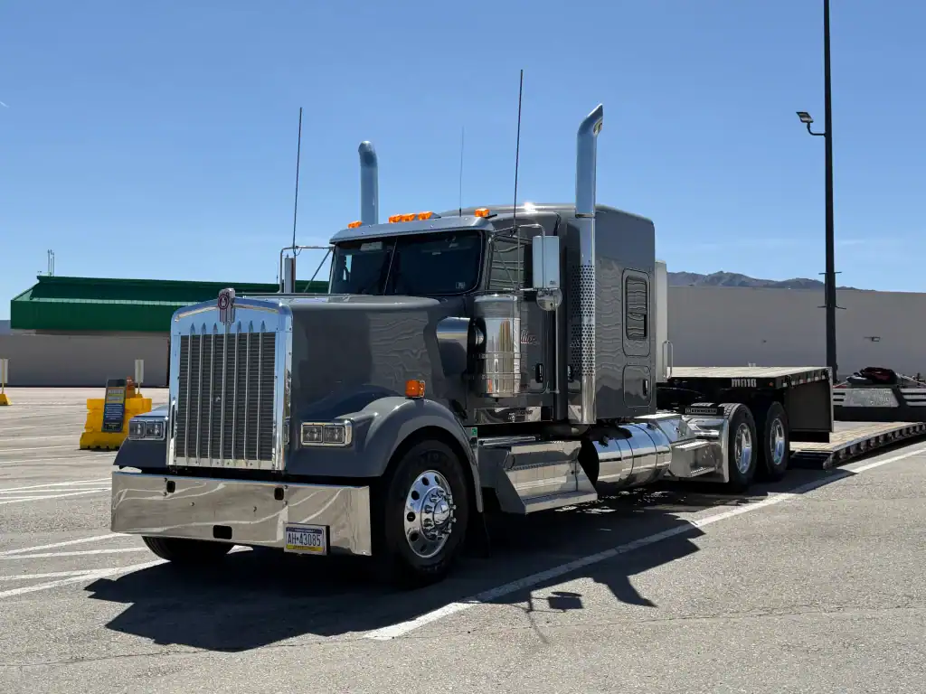 Gray semi-truck with flatbed trailer parked at a Southern California yard