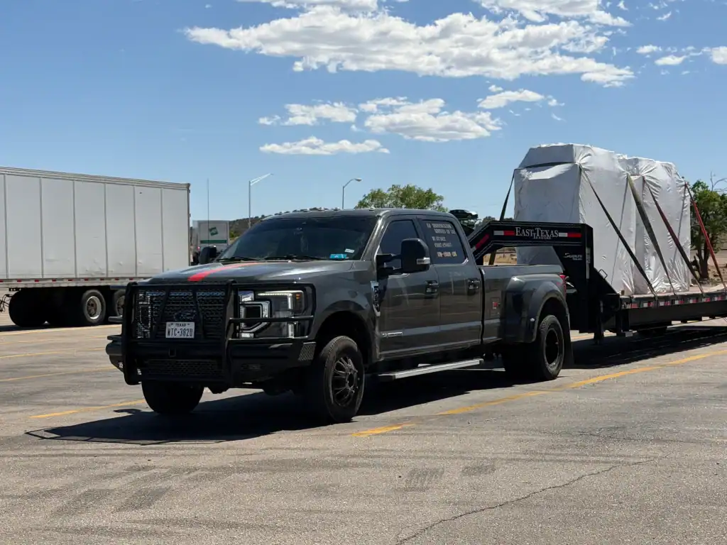 Heavy-duty pickup towing a covered flatbed load, eligible for CARB testing