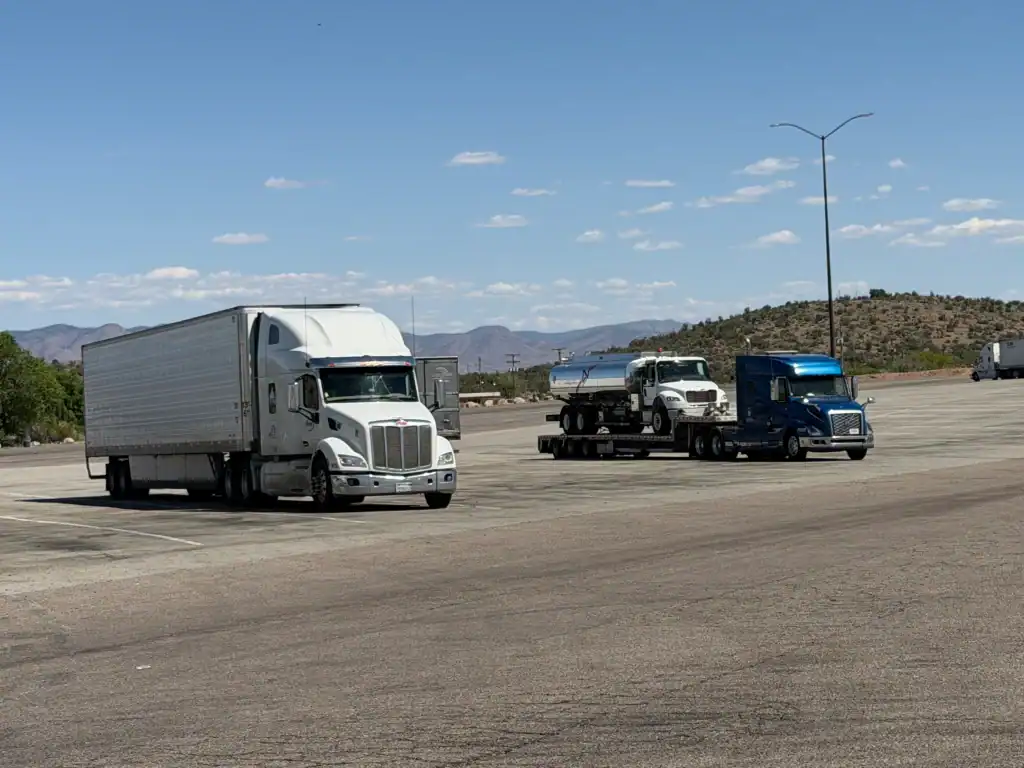 Two semi-trucks in an open lot before mobile Clean Truck Check service